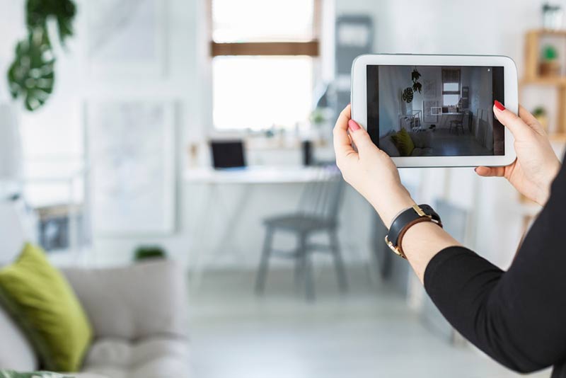 Woman taking photo of apartment with tablet