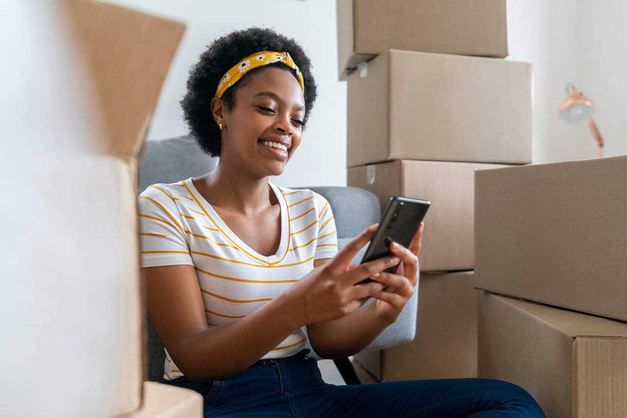 Prospective renter using a smartphone while moving into a new home.